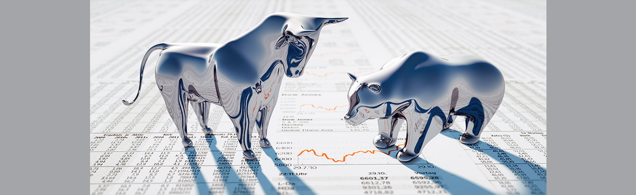 Silver Bull and Bear standing on a financial Newspaper.