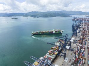 Aerial view of a fully loaded cargo ship leaving port.